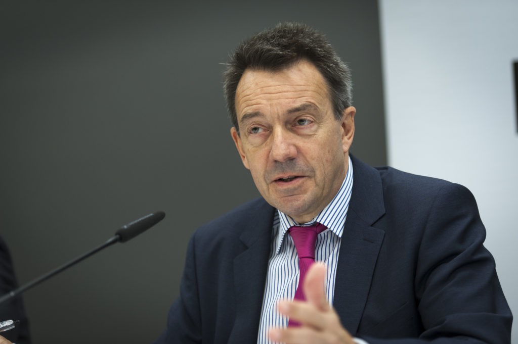 A man in a suit and tie, representing the international committee of the red cross, is speaking into a microphone.