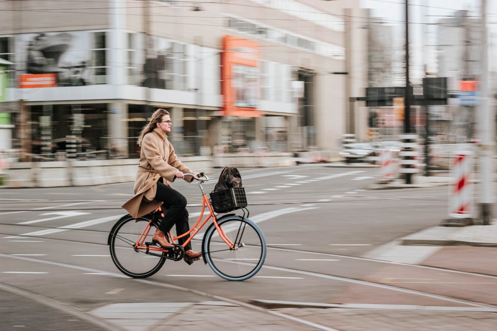A woman commuting on a bicycle on a city street.
