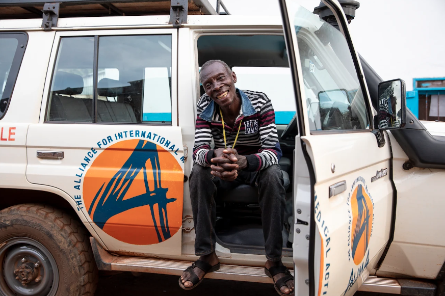 A man sits in the front seat of a jeep.