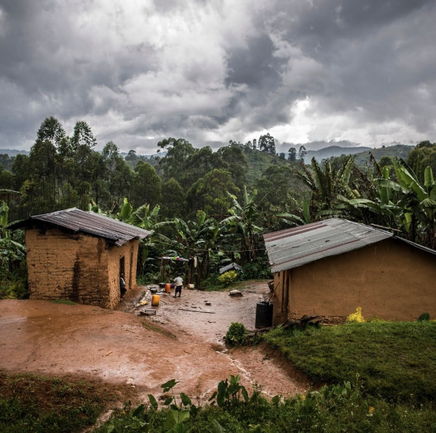 A small village with a muddy road and a cloudy sky, where the published carbon footprints of its inhabitants are monitored.