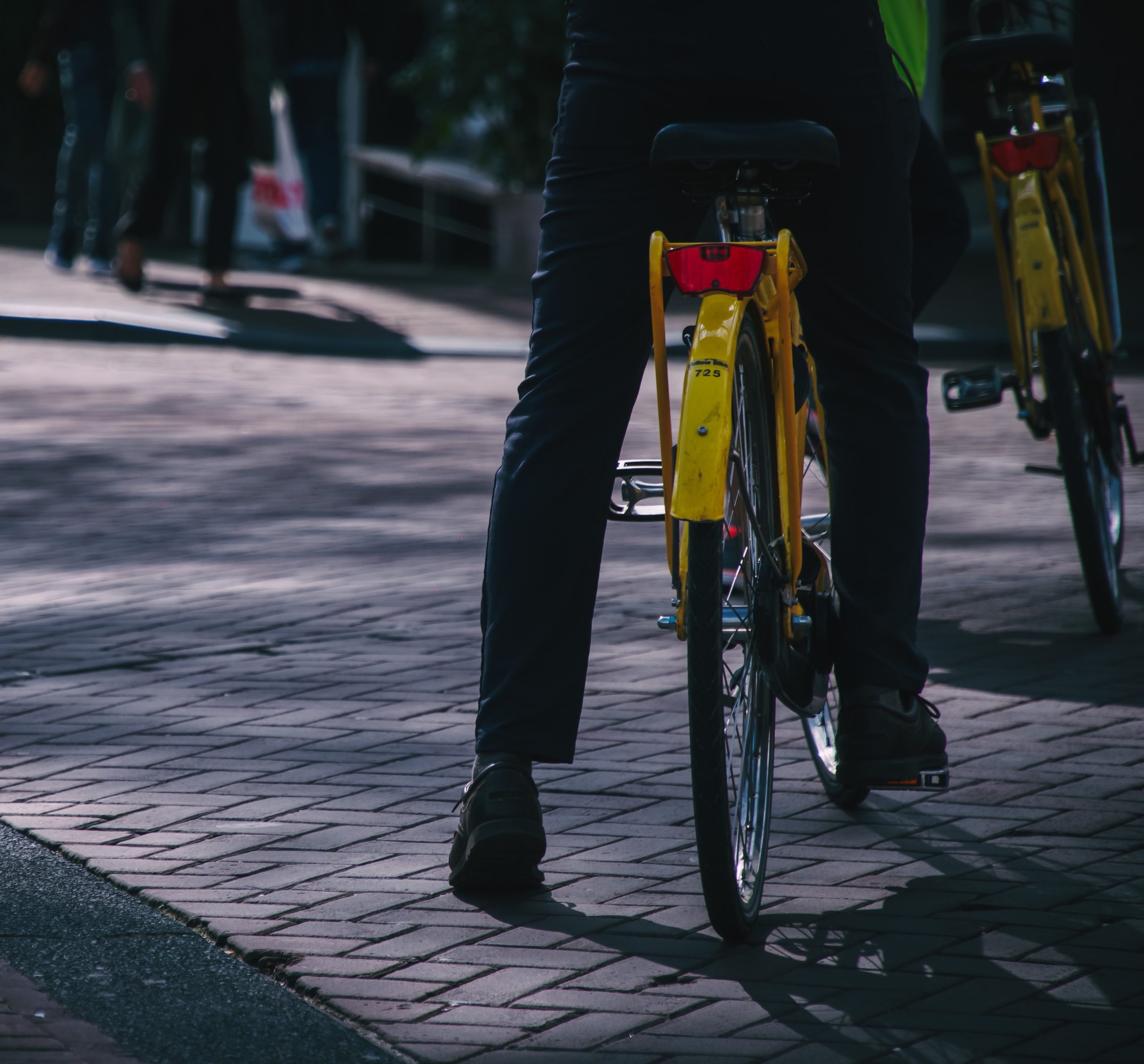 An individual riding a green bicycle.