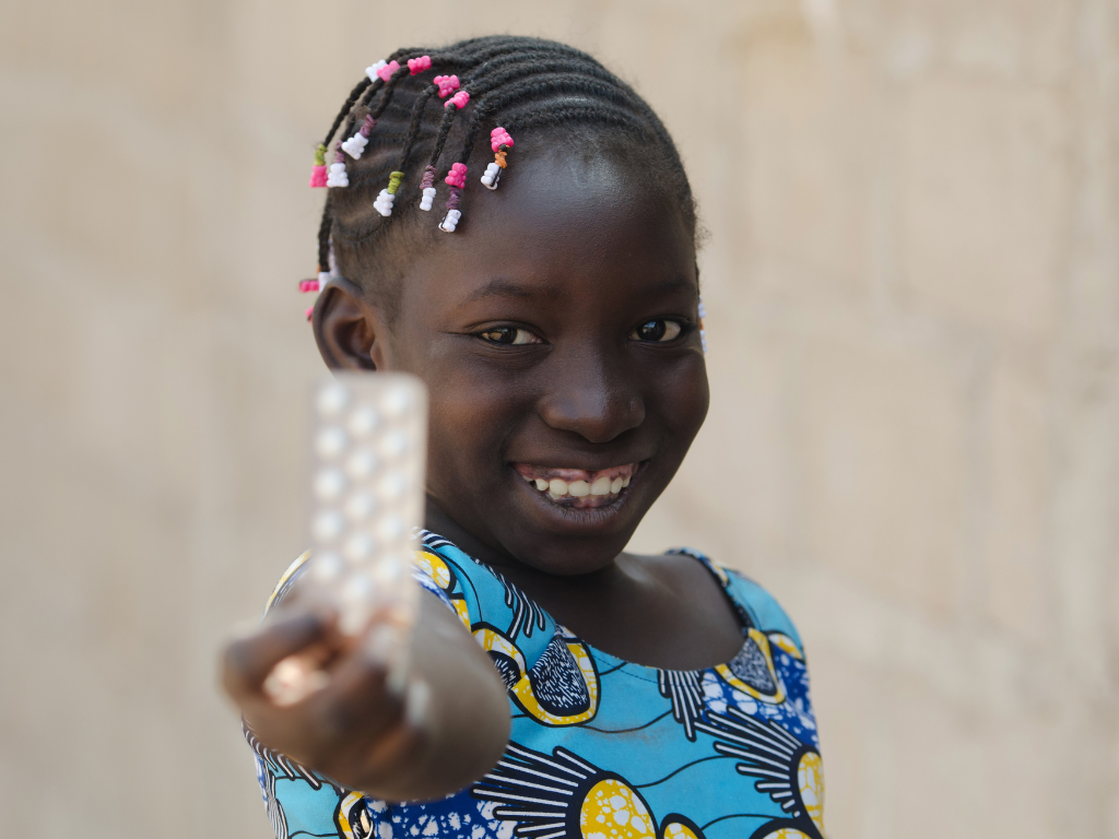 A young girl is holding up a piece of paper in front of target sectors.