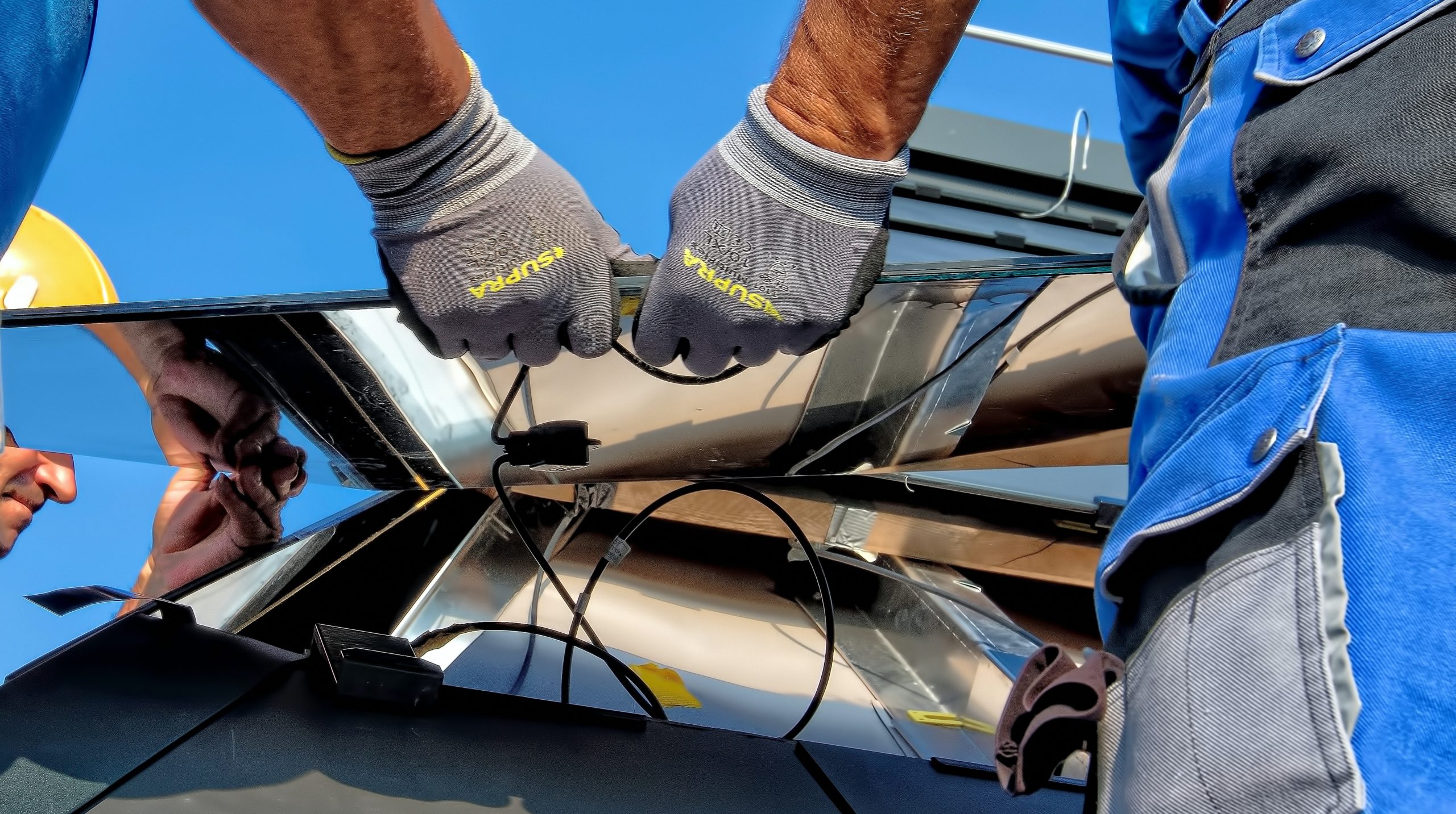 Two men repairing a solar panel.